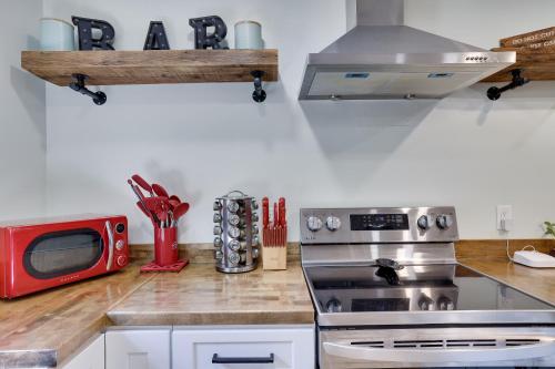 a kitchen with a stove and a red microwave at Apartment Minutes from Camelback Mountain with Washer Dryer in Tannersville