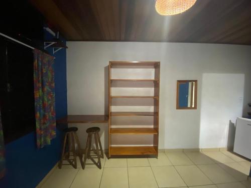 a room with a shelf and some stools in it at Pousada Figueira in Trindade