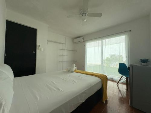 a bedroom with a large white bed and a window at Casa Balam Cayo Lobo in Cancún