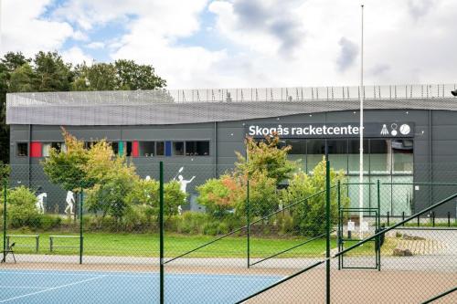 a tennis court in front of a building at Apartment in Skogås in Skogås