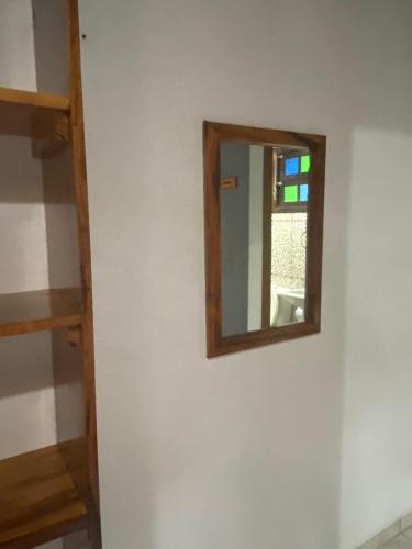 a mirror on a wall in a room at Pousada Figueira in Trindade