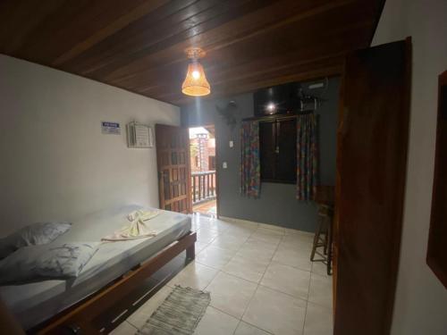 a bedroom with a bed and a hallway with a window at Pousada Figueira in Trindade