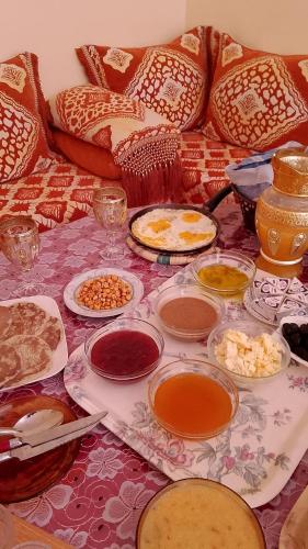 a table with many plates of food on a couch at Adoir N'salh in Tiznit