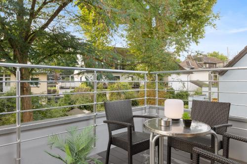ein Balkon mit zwei Stühlen und einem Tisch mit Aussicht in der Unterkunft Svyvo Apartments Brühl - Parking Kitchen Balcony in Brühl
