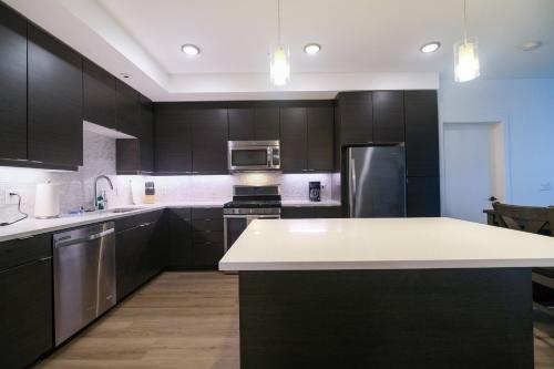 a kitchen with black cabinets and a white counter top at Multiple Hollywood Apartments Hub in Los Angeles