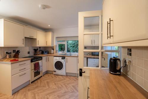 a kitchen with white cabinets and a wooden floor at Ames Cottage in Hinton