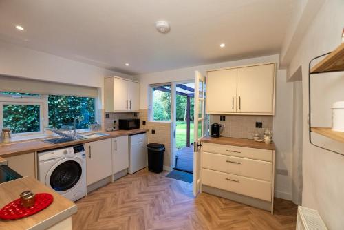 a kitchen with white cabinets and a washer and dryer at Ames Cottage in Hinton