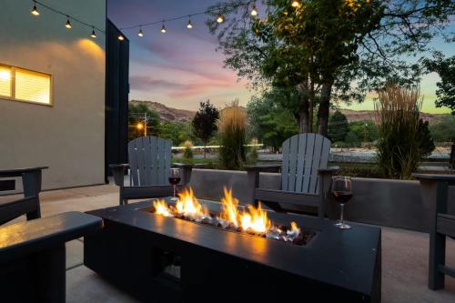 a fire pit in a patio with two chairs and wine glasses at Near Downtown Stylish 2BR With Amazing Patio - #2 in Moab