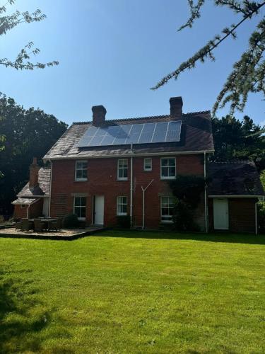 a large red brick house with solar panels on the roof at Red House in Hinton