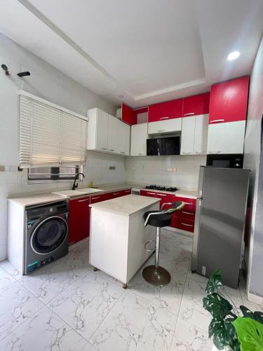 a kitchen with red and white cabinets and a dishwasher at MBA Lux & suites in Maiyegun
