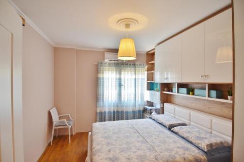 ein Schlafzimmer mit einem Bett und einem Stuhl darin in der Unterkunft West Beach Apartment in Durrës