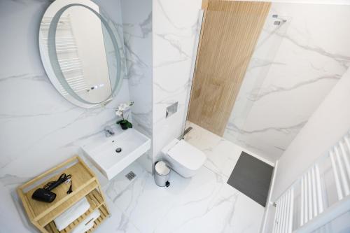 une salle de bain blanche avec un lavabo et un miroir dans l'établissement High comfort by Best Residence, à Bucarest