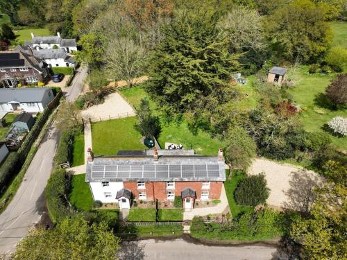 an aerial view of a house with solar panels on it at Foxglove Cottage in Bransgore