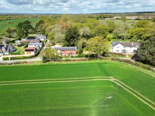 an aerial view of a large green field with houses at Foxglove Cottage in Bransgore