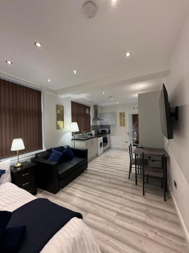 a hotel room with a bed and a living room at Stylish Studio Apartment in Leicester
