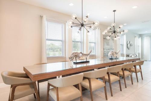 a dining room with a large wooden table and chairs at Gorgeous Home With Private Pool, Themed Rooms Near Disney With Waterpark & Resort Access At Encore Resort - 7687Ff in Kissimmee