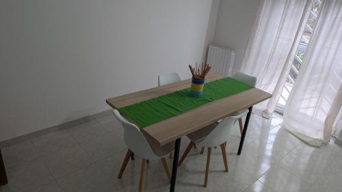 a table with chairs and a cup of pencils on it at Appartamento in residence "CASA DAMIA" in Taranto