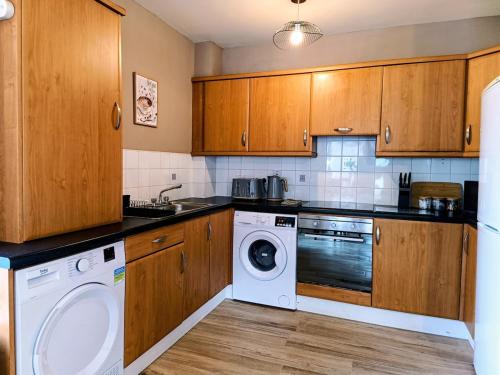 a kitchen with a washing machine and a washer at City Centre C Apartment, Parking, Ground Floor in Belfast