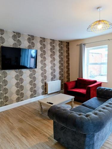 a living room with a couch and a tv on a wall at City Centre C Apartment, Parking, Ground Floor in Belfast