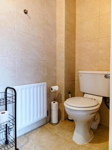 a bathroom with a toilet and a radiator at City Centre C Apartment, Parking, Ground Floor in Belfast