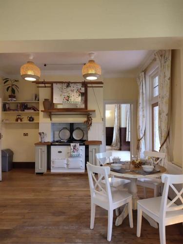 a kitchen and dining room with a table and chairs at Arnewood Manor in Sway