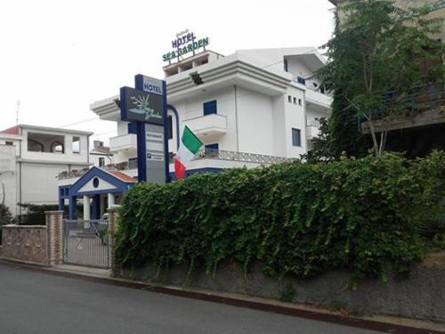 a building with a sign in front of a hedge at Sea Garden Hotel in Acquappesa