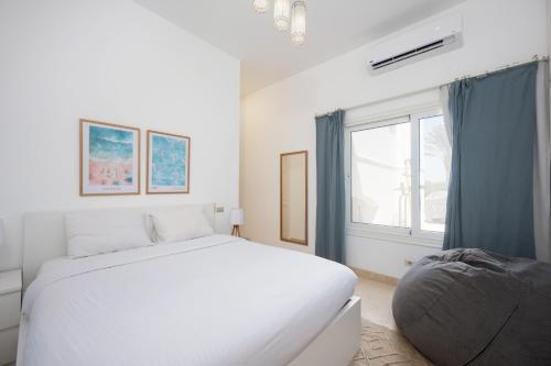 a white bedroom with a large bed and a window at VESTA - El Gouna Residence in Hurghada