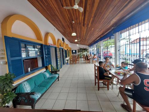 a restaurant with people sitting at tables in a building at Pousada do Marcão in Ubatuba