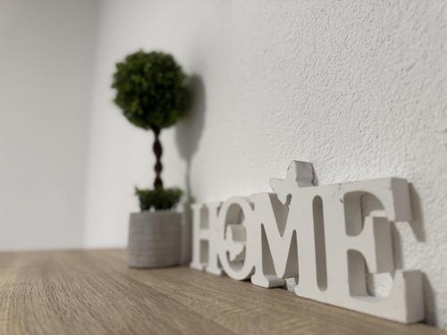a wooden sign that says learn next to a plant at Ramoni Apartments in Hochwiese