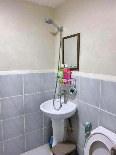 a bathroom with a sink and a mirror and a toilet at RnB Stayction in Lapu Lapu City