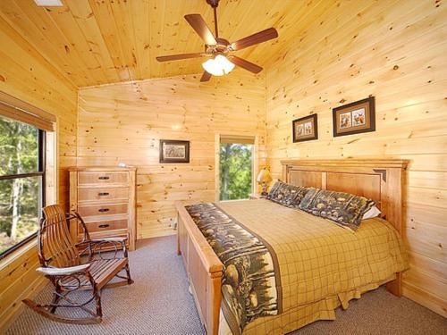 een slaapkamer met een bed en een plafondventilator bij Lumberjack Lodge Holiday home in Gatlinburg