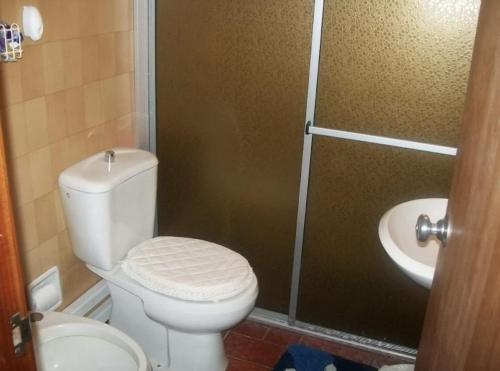 a bathroom with a toilet and a shower and a sink at Cheroga in La Pedrera