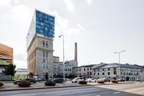 a building on a street with cars parked in a parking lot at Fahle building, skyline view 1 bedroom Flat near Centre in Tallinn