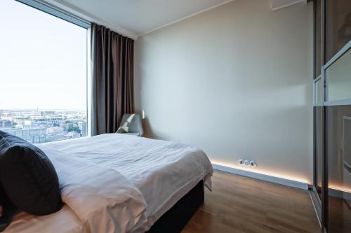 a bedroom with a bed and a large window at Fahle building, skyline view 1 bedroom Flat near Centre in Tallinn