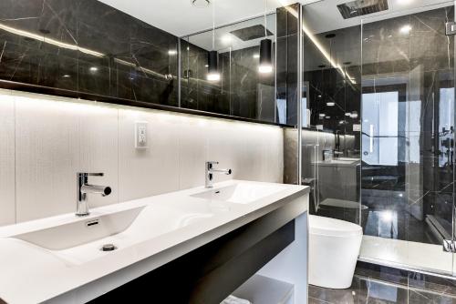a bathroom with two sinks and a toilet at CLUBHAUS Hotel in Montréal