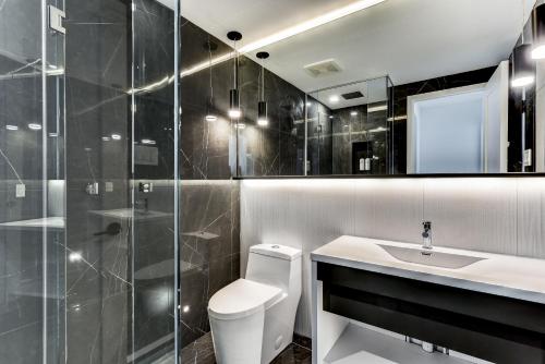 a bathroom with a toilet and a sink and a shower at CLUBHAUS Hotel in Montréal
