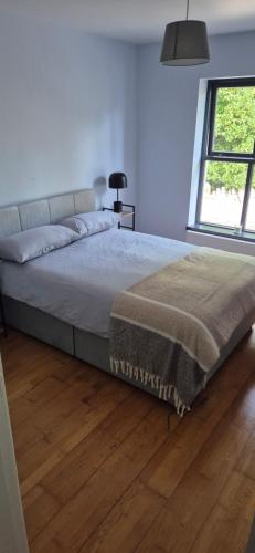Una cama grande en un dormitorio con suelo de madera. en Rock garden, en Cong