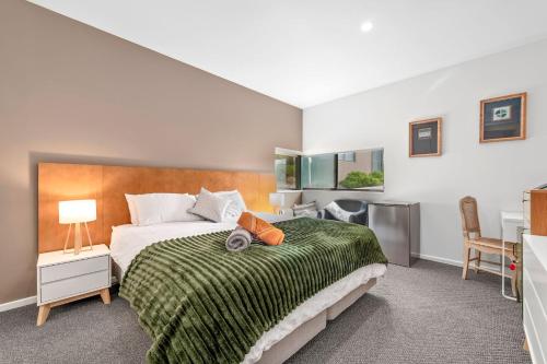 a bedroom with a bed with a green blanket at 1BR Apartment 43 sleeps 5,Golf,Beach,Hot Springs in Fingal