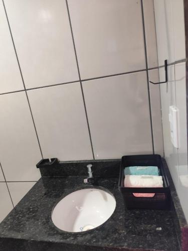 a bathroom with a black counter with a sink at Espaço Quintal do Encontro in Ponta Porã