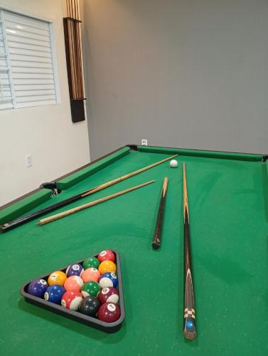 a pool table with billiard balls and cues on it at Espaço Quintal do Encontro in Ponta Porã