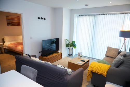 a living room with two couches and a television at Cosy Two bedroom Apartment in Manchester in Manchester