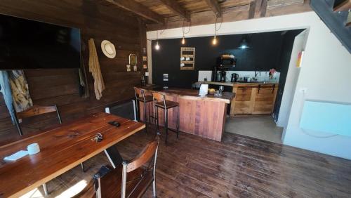 a kitchen with a wooden table and a bar at Cabaña rústica con pileta tipo playa en Salta Capital in Salta