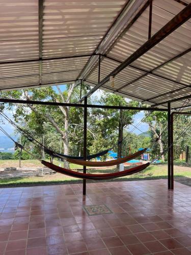 a hammock in a building with a view of a park at Sikeo Eco Glamping in Icononzo