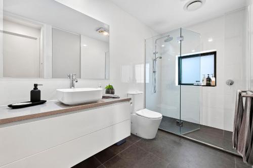 a white bathroom with a sink and a toilet at 1BR Apartment 43 sleeps 5,Golf,Beach,Hot Springs in Fingal