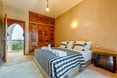 a bedroom with a bed with a blue and white blanket at Riad du Bab atlas in Marrakesh