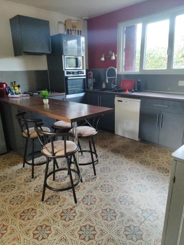 a kitchen with a wooden table and four chairs at Chambre a 5 min de Center Parc bois aux daims in Les-Trois-Moutiers