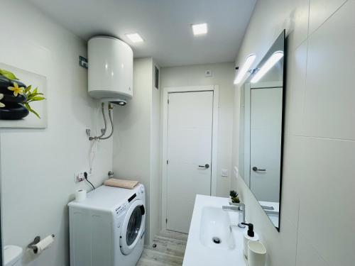 a bathroom with a washing machine and a sink at Apartamento con piscina y balcón recién reformado in Platja  d'Aro