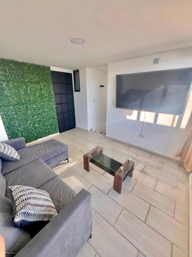 a living room with a couch and a large screen tv at Casa en Fraccionamiento Privado con alberca in Cuautlancingo