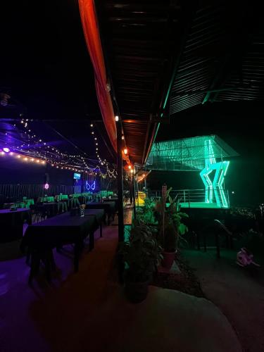 a restaurant with tables and lights at night at Estrella verde Lodge in Pejibaye