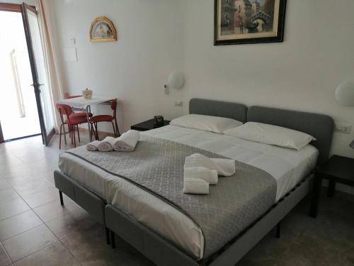 a bedroom with a bed with towels on it at CASA VACANZE gli ULIVI 23 in Sìnnai